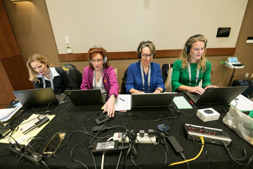 Image of the Caption Pros team at a table